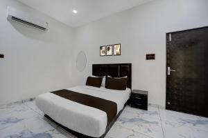 a bedroom with a large bed in a white room at Hotel O Choice Inn II in Rao