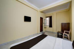 HabībganjにあるHotel O Balaji Palaceのベッドルーム1室(大型ベッド1台、壁掛けテレビ付)