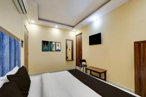 HabībganjにあるHotel O Balaji Palaceのベッドとテーブルと椅子のある寝室