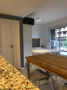 a room with a table and a bedroom with beds at Comen 4 pican 5!! in Buenos Aires