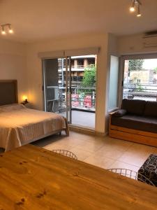 a bedroom with a bed and a couch and a window at Comen 4 pican 5!! in Buenos Aires