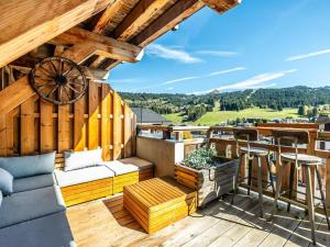 - un balcon avec un canapé et une table sur le toit dans l'établissement Appartement de prestige spacieux et lumineux avec sauna et parking inclus - FR-1-598-48, aux Gets