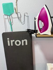 a iron hanging on a wall next to a sign at 1 Mile To Fsu-artsy Tree-house in Zion Hill