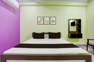 a bedroom with a large bed with purple and green walls at Hotel O SAI KRISHNA GUEST HOUSE in Kendrāparha
