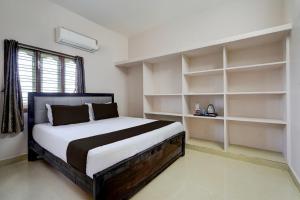 a bedroom with a large bed with white shelves at Hotel O V Stayinn in Renigunta