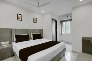 a bedroom with a large bed and a television at Hotel O Royal in Ambli Road +30 photos