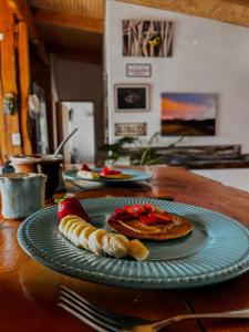a table with pancakes and strawberries on a plate at refugio el bagual in Futaleufú