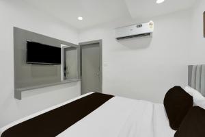 a bedroom with a bed with a tv on the wall at Hotel O Royal in Ambli Road