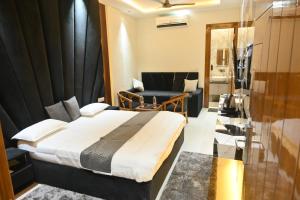 a hotel room with a bed and a chair at Hotel Glumol in Roorkee