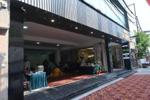 a store front of a building with people sitting at tables at Hotel Glumol in Roorkee