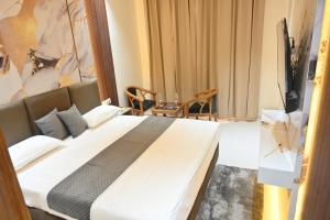 a hotel room with a large bed and a television at Hotel Glumol in Roorkee