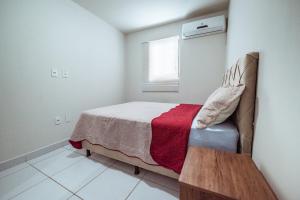a small bedroom with a bed and a window at Apartamento com garagem a 200m da Praia do Bessa in Tambaú