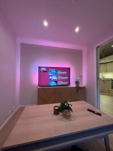a purple room with a table and a tv at Central loft apartment, with a view from the roof terrace in Tromsø