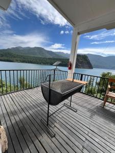 Una bañera situada en una terraza junto a un cuerpo de agua. en Complejo Turístico Alto Pangue, en Callaqui