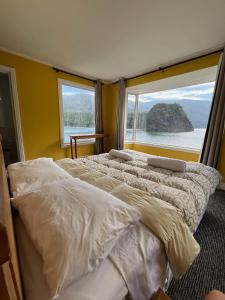 Dos camas en una habitación con una gran ventana. en Complejo Turístico Alto Pangue, en Callaqui