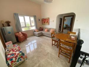 a living room with a table and a couch at Sunset Views in Muscat
