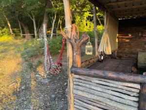 eine Veranda mit Hängematten und einem Holzzaun in der Unterkunft Cottage Qorbuda in Saguramo + 5 Fotos