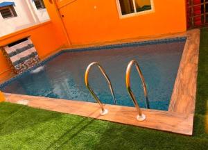 a swimming pool with two handles in an orange building at SERENITY BAY HOME 2bhk in Pondicherry