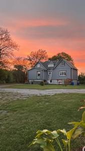 een groot huis met een zonsondergang op de achtergrond bij Charmig Ölandsgård in Köpingsvik