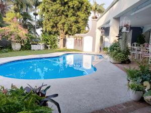 a swimming pool in a yard next to a house at Villa Roc Guesthouse - Solar Power in Ballito