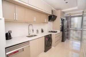 a kitchen with a sink and a washing machine at Luxury Apartment with Sea View & Free Parking in Tangier
