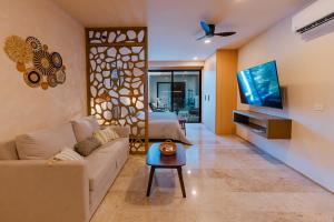 a living room with a couch and a tv at New Luxury Studio in the City Center in Playa del Carmen