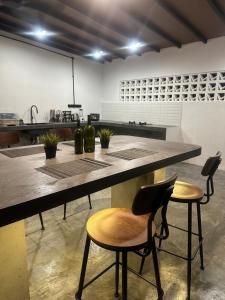 a kitchen with a large counter with two chairs at Zar House With Swimming Pool in Malacca +34 photos