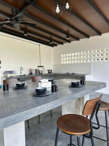 a large kitchen with chairs and a large counter at Zar House With Swimming Pool in Malacca