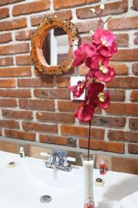 een vaas met roze bloemen op een wastafel bij Hotel Campestre El Rinconcito de Chigna in Chignahuapan