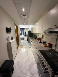 une cuisine avec des armoires blanches et un comptoir dans l'établissement Livincci - Luxury Studio Burj Khalifa View - 12, à Dubaï