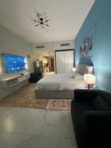 une chambre avec un grand lit et une télévision dans l'établissement Livincci - Luxury Studio Burj Khalifa View - 12, à Dubaï