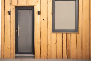 Un edificio de madera con dos puertas y un cartel. en Wohngefühl Appartements Bad Tabarz - Wohlfühlnest, en Tabarz 2 fotos más