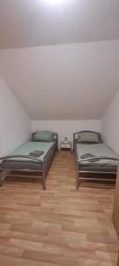 two beds in a room with a wooden floor at FeWo Spelle in Spelle