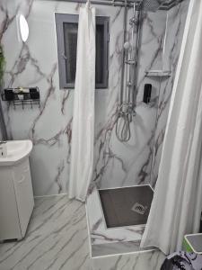 Un baño con cortina de ducha y lavabo. en Kucko Vendeghaz Guesthouse, en Sárospatak
