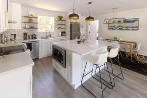 a kitchen with a white island with a microwave at Manchaca Meadows Mini Villa Pool & Spa 20 min DT in Manchaca