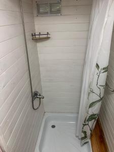 a bathroom with a bath tub with a shower at Danan - Cabañas granero en Andino in Andino +8 photos