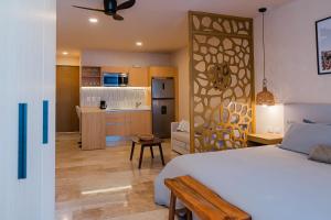 a bedroom with a white bed and a kitchen at New Luxury Studio in the City Center in Playa del Carmen