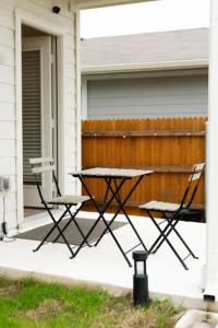 オースティンにあるTesla Luxe Retreat Sleeps 10のピクニックテーブル、椅子2脚付きのポーチ