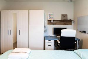 オースティンにあるTesla Luxe Retreat Sleeps 10のベッドとパソコン付きの机がある寝室