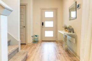 オースティンにあるTesla Luxe Retreat Sleeps 10の白いドアとウッドフロアの廊下