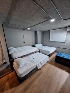 a room with three beds and a couch in it at Eureka Living in Bucaramanga