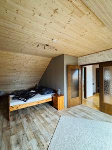 SiptenfeldeにあるHaus Hasenlandの木製の天井が特徴のベッドルーム1室(ベッド1台付)