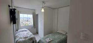 a small bedroom with a bed and a window at Hotel Rex in Lages +12 photos