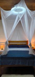 a bedroom with a bed with a mosquito net at Casa de Andréa in Santo António