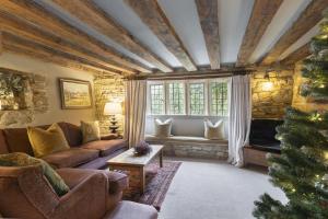 a living room with a couch and a christmas tree at Idyllic Cotswold Cottage Near Broadway in Badsey
