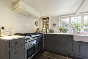 a kitchen with a stove and a sink at Idyllic Cotswold Cottage Near Broadway in Badsey +30 photos