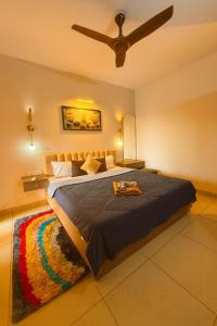 a bedroom with a large bed with a ceiling fan at Sunset View High Floor Apartment with Pool & Jacuzzi in Siolim +18 photos