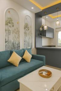 a living room with a blue couch and a table at Sunset View High Floor Apartment with Pool & Jacuzzi in Siolim