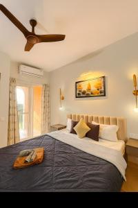a bedroom with a large bed with a ceiling fan at Sunset View High Floor Apartment with Pool & Jacuzzi in Siolim