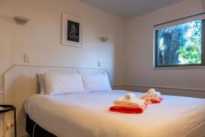a bedroom with a bed with towels on it at Beachfront on Waiheke in Onetangi